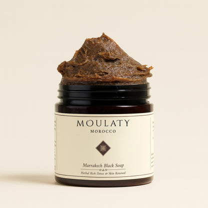 Jar of Marrakech black soap with herbal-rich textured paste for gentle exfoliation and detox.