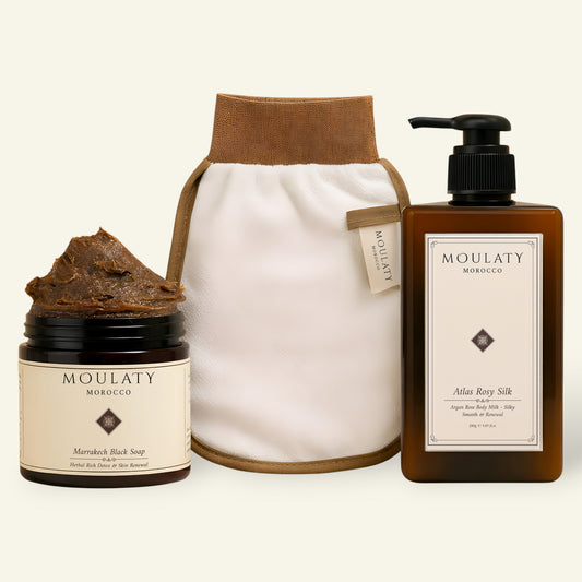 Moroccan skincare set with Marrakech black soap, exfoliating glove, and Atlas Rosy Silk body milk