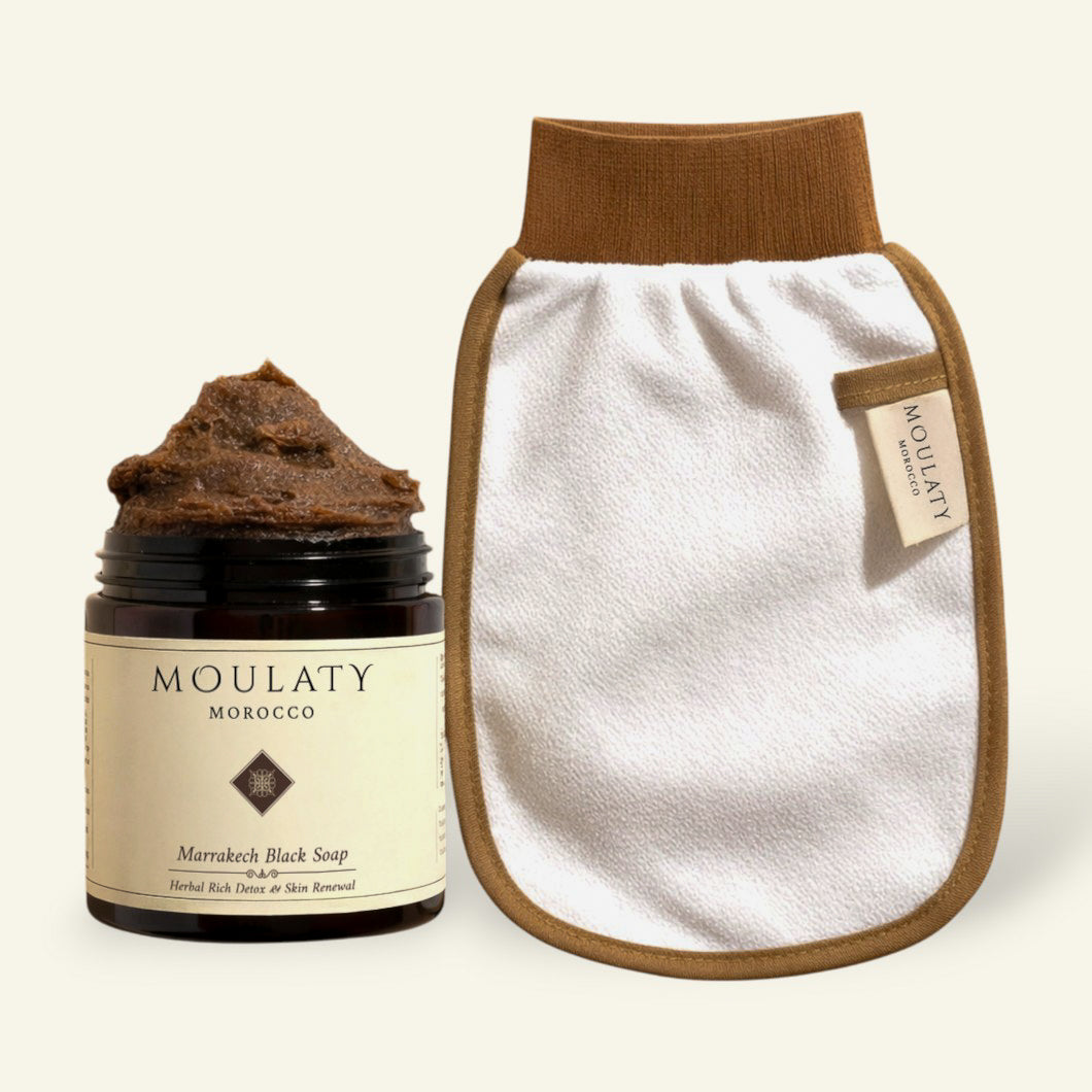 Moroccan black soap jar with exfoliating glove for hammam skincare and gentle cleansing.