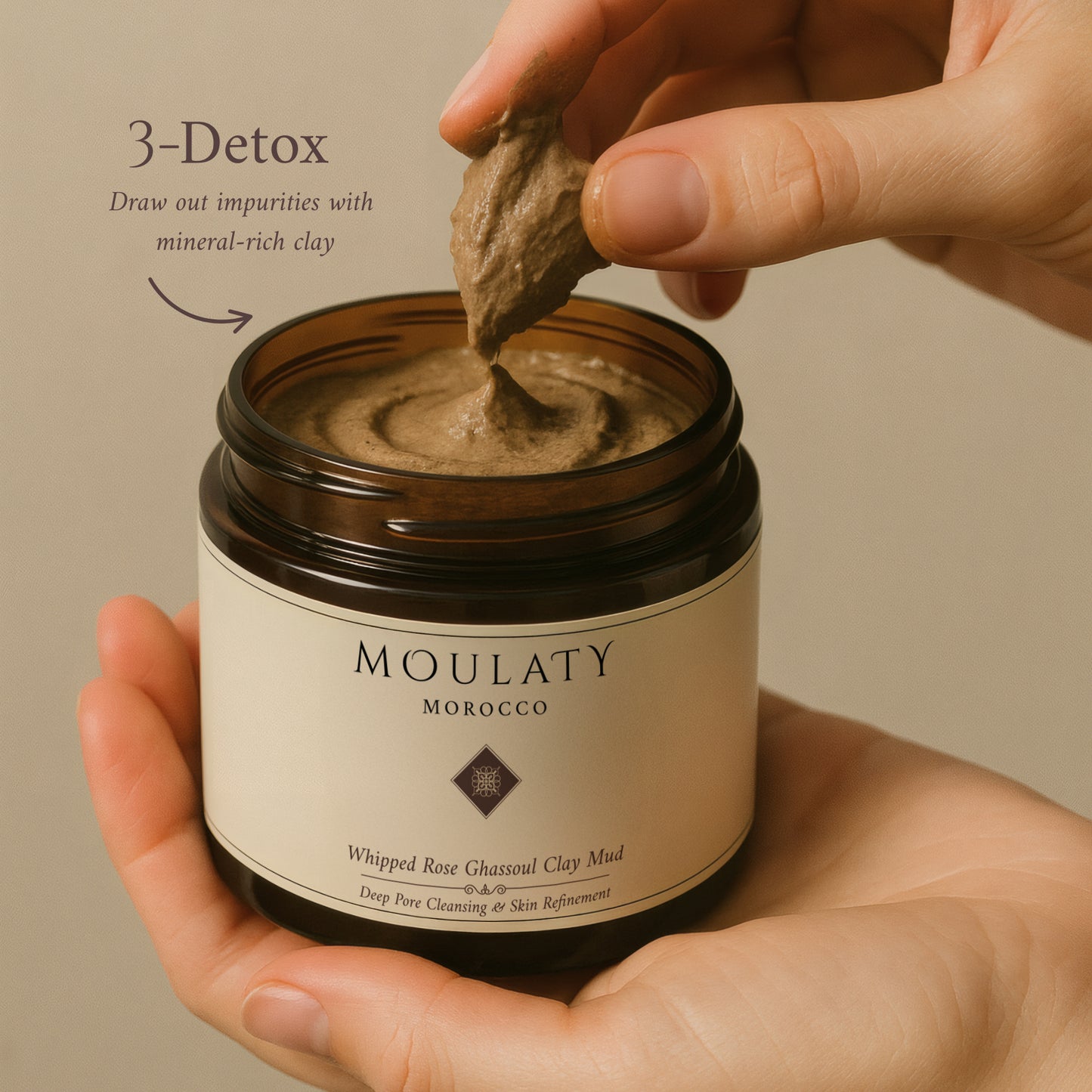 Hand holding jar of whipped rose Ghassoul clay mud mask for deep pore cleansing.